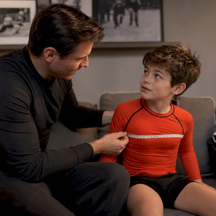 Parent measuring child's hockey shirt size