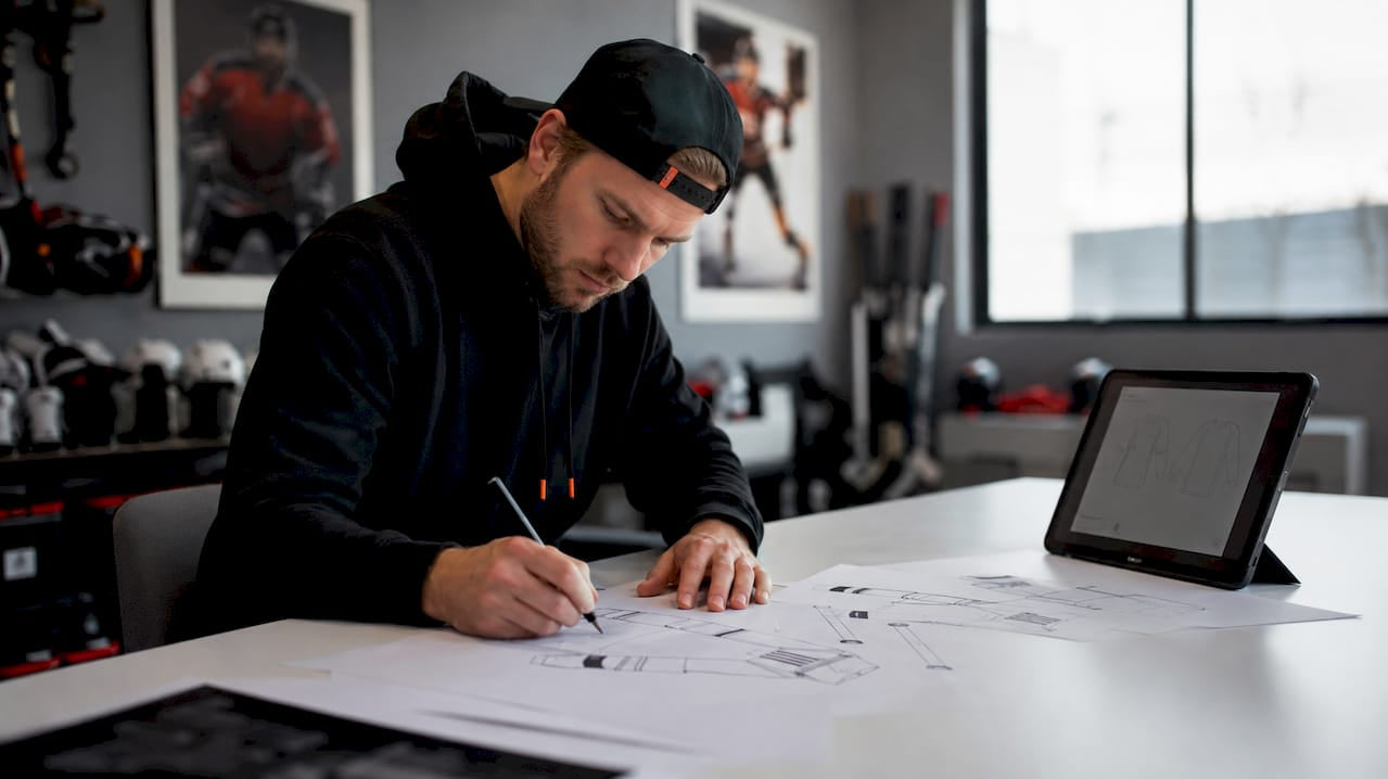 Youth hockey coach designing custom apparel at table