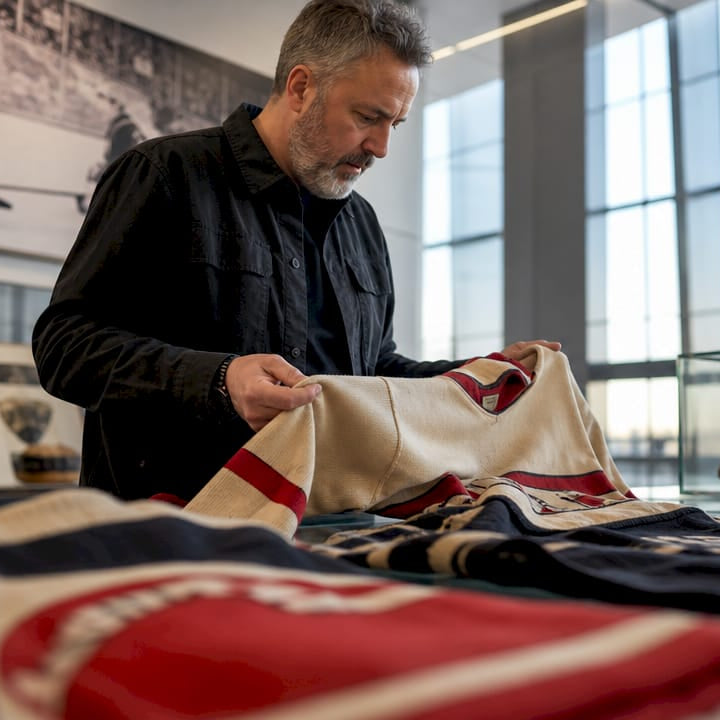 Historian examining vintage hockey jerseys