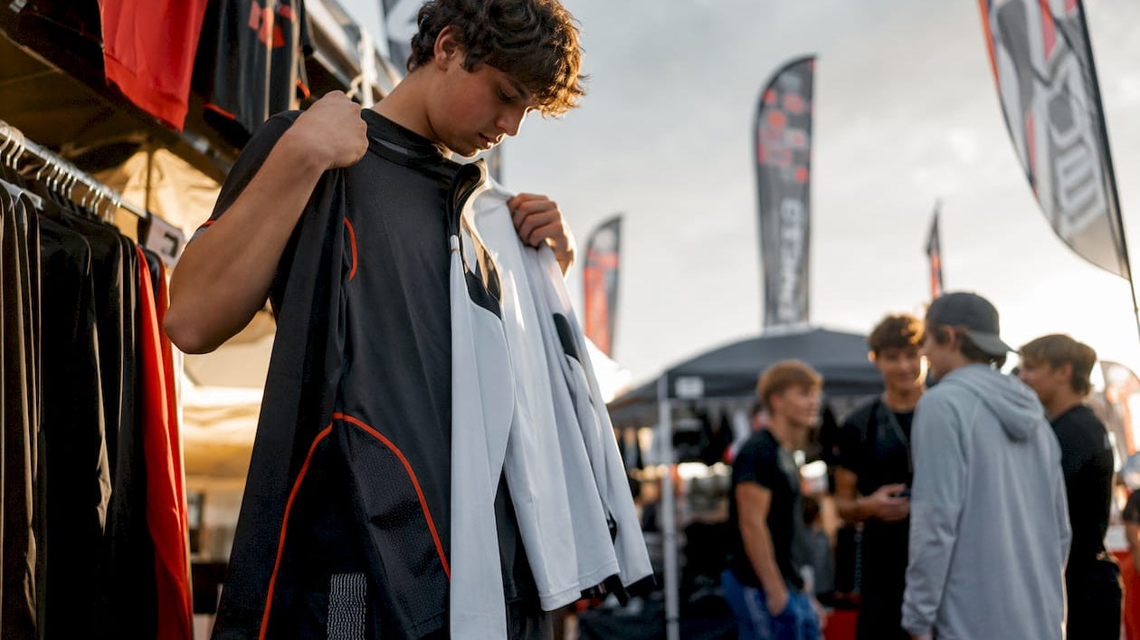 Teen hockey player choosing moisture-wicking shirts in store