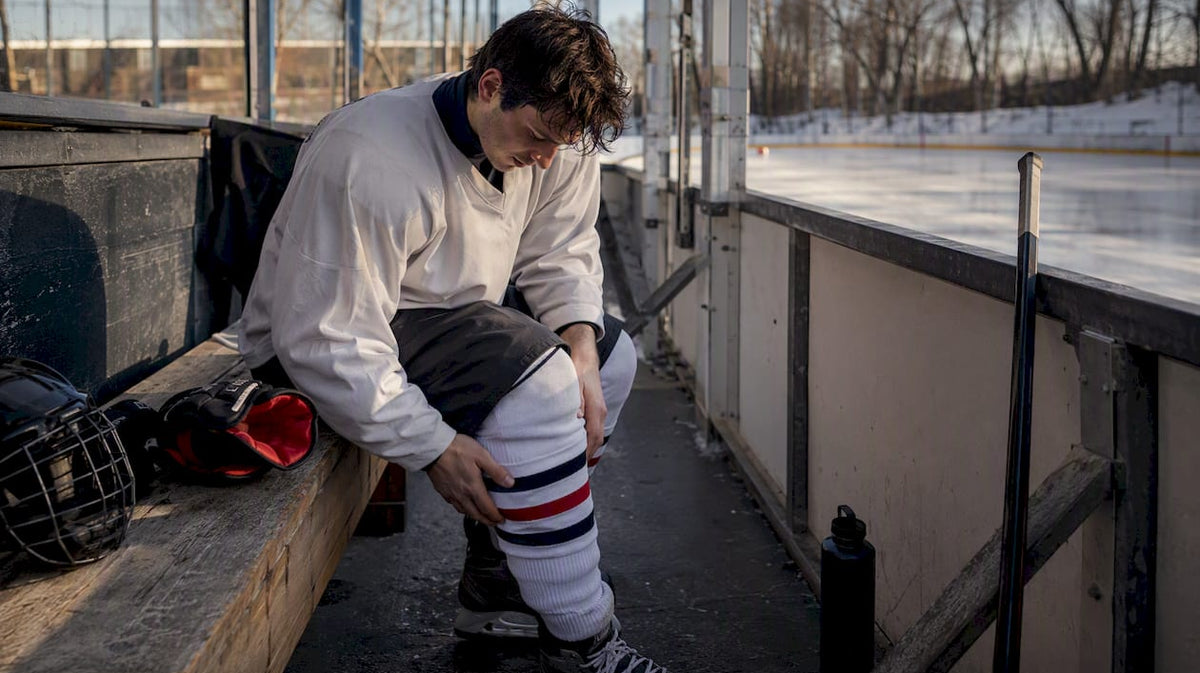 Hockey player adjusting pads and jersey