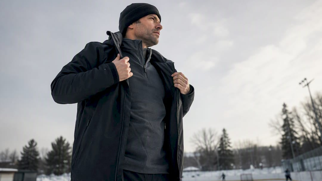 Coach layering hockey apparel on bench