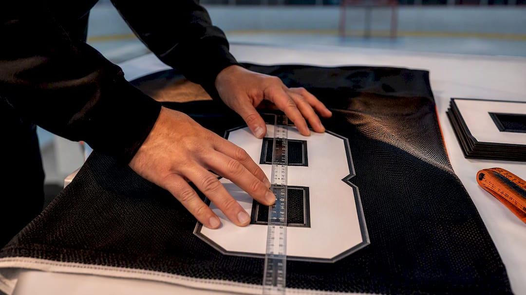 Coach checking hockey jersey number placement