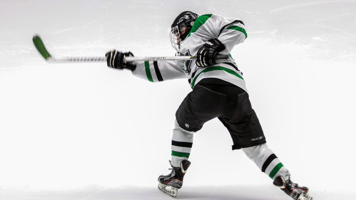 man wearing green and white ice hockey jersey while playing