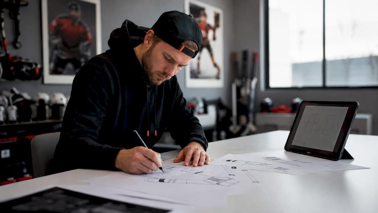 Youth hockey coach designing custom apparel at table