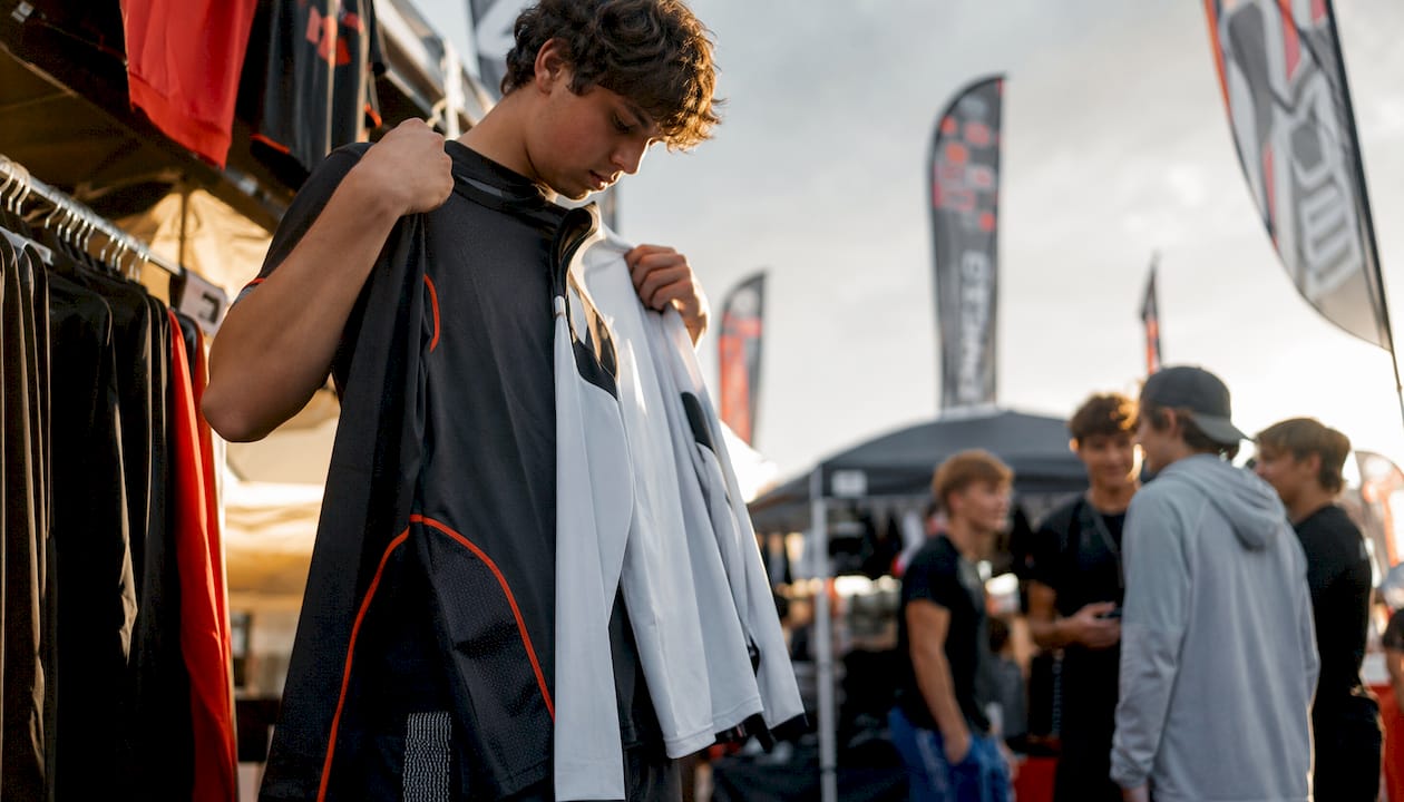 Teen hockey player choosing moisture-wicking shirts in store