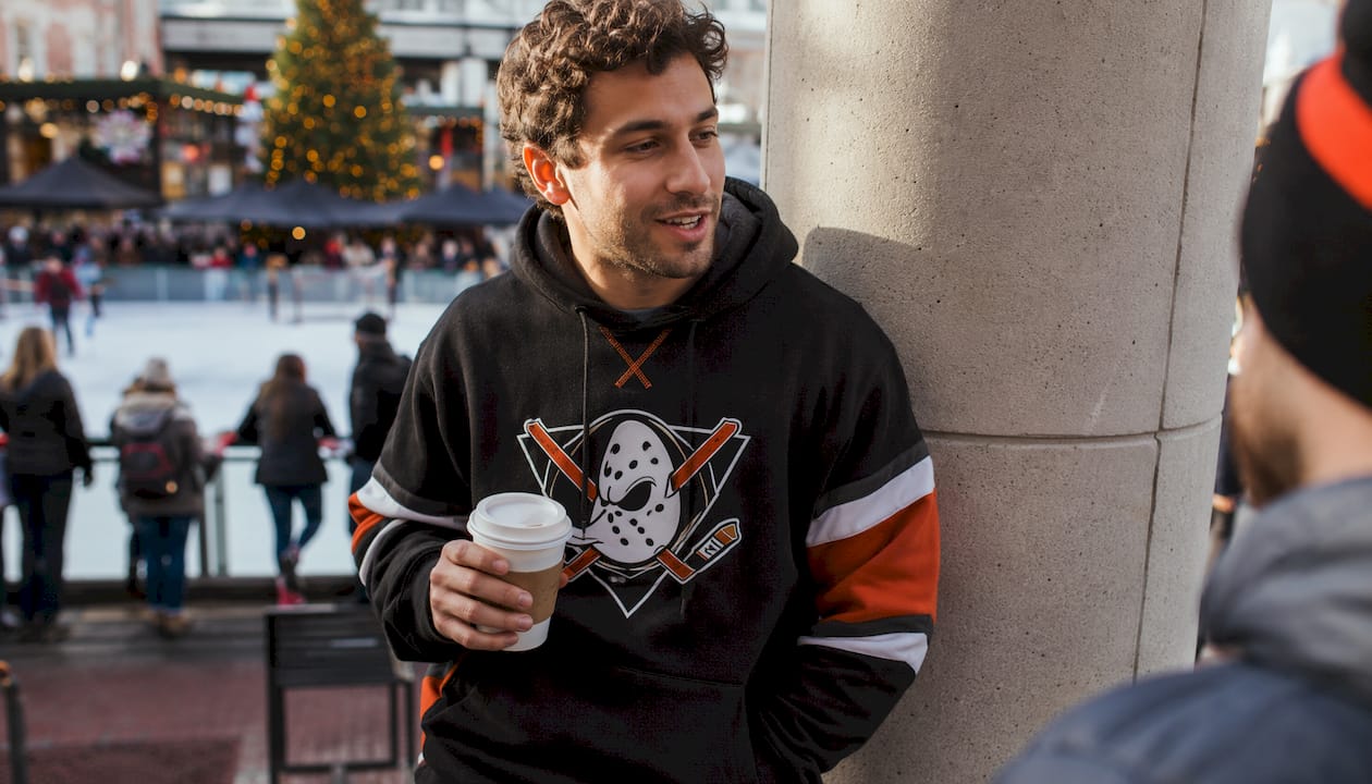 Fan wearing hockey supporter hoodie in arena concourse