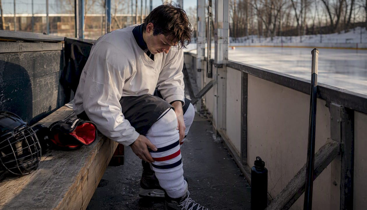 Hockey player adjusting pads and jersey