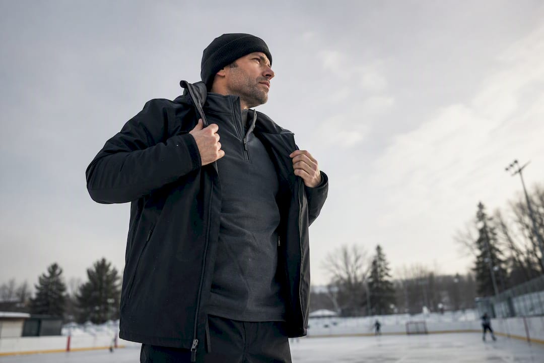 Coach layering hockey apparel on bench