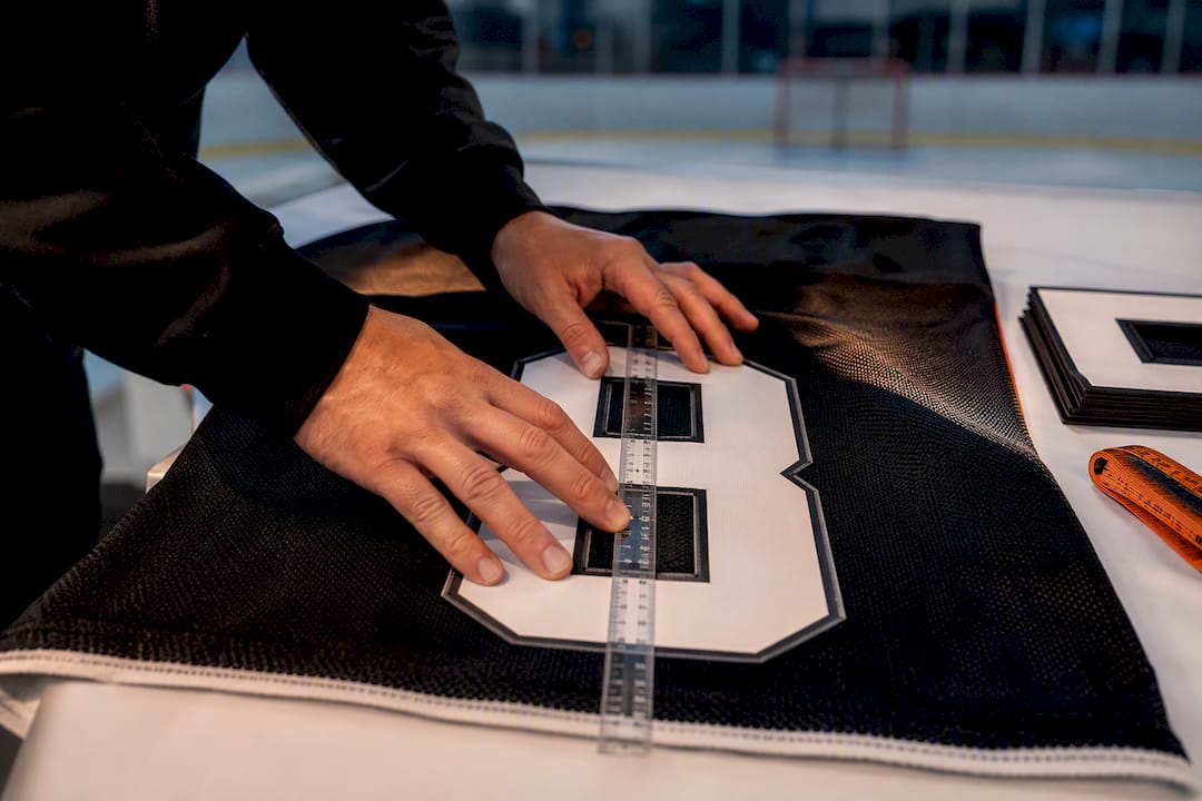 Coach checking hockey jersey number placement